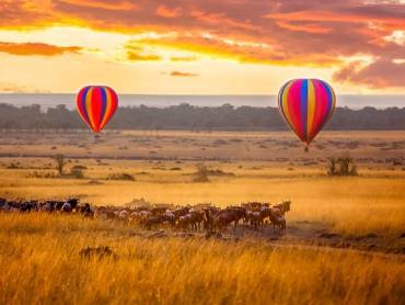 Sonnenaufgang in der Masai Mara mit Ballons und Gnuherde