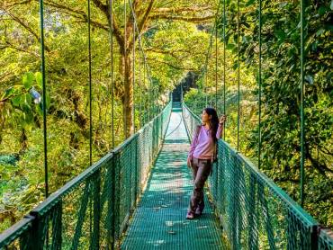 Frau auf Hngebrcke im Nebelwald Monteverde